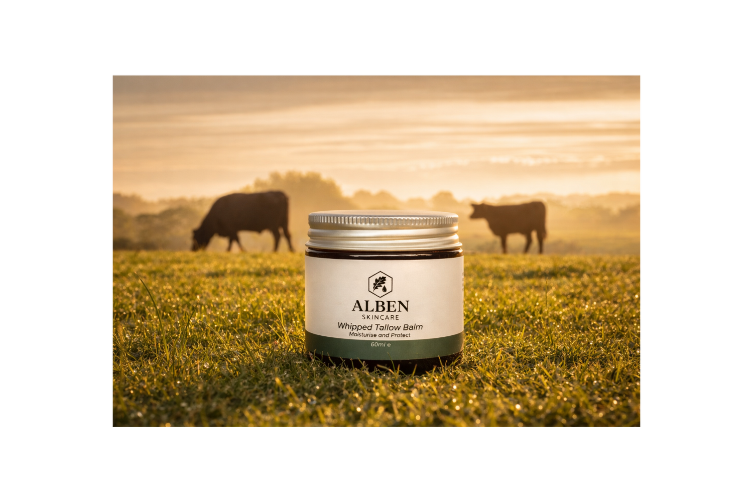 Alben skincare balm jar on grass with cows in the background